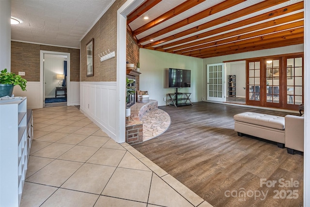 living area featuring wainscoting, a fireplace, and light wood-type flooring