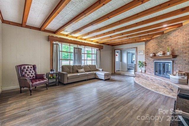 living area with wood finished floors, a fireplace, and beam ceiling