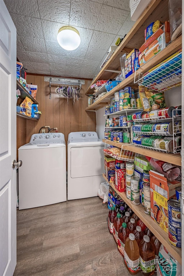 laundry area featuring washer and dryer, wood finished floors, and wooden walls