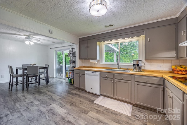 kitchen with dishwasher, a sink, wooden counters, crown molding, and gray cabinetry