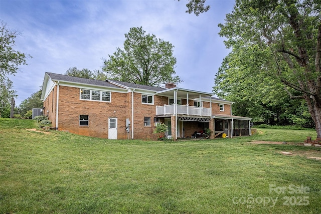 rear view of house featuring brick siding, a lawn, a wooden deck, and a chimney