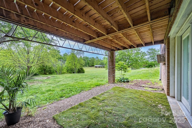 view of grassy yard with view of wooded area