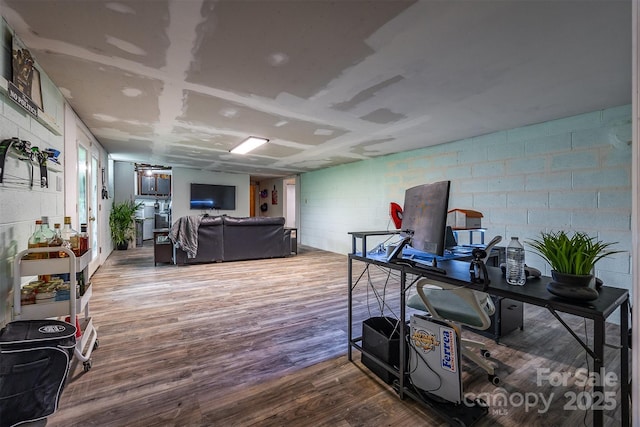 miscellaneous room featuring wood finished floors and concrete block wall