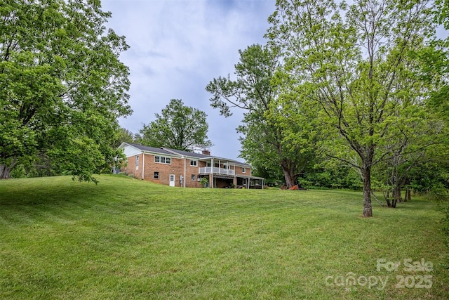 view of green lawn featuring a deck
