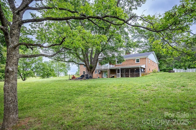 view of grassy yard with a sunroom