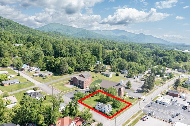 aerial overview of property's location with a heavily wooded area, mountains, and property boundaries highlighted