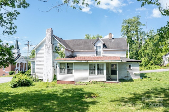 back of house with a yard and a chimney