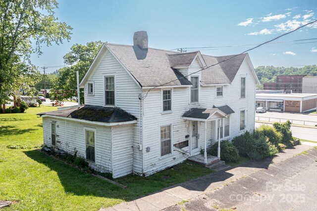 view of front of house with a chimney and a front lawn