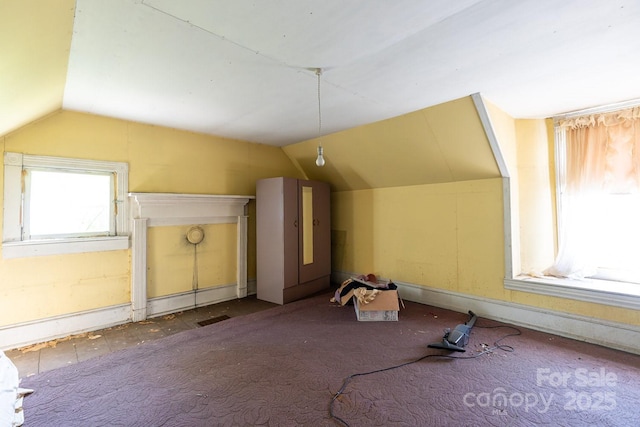 bonus room with vaulted ceiling and carpet floors