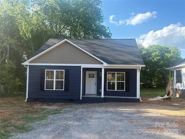 view of front of property featuring covered porch, roof with shingles, and crawl space