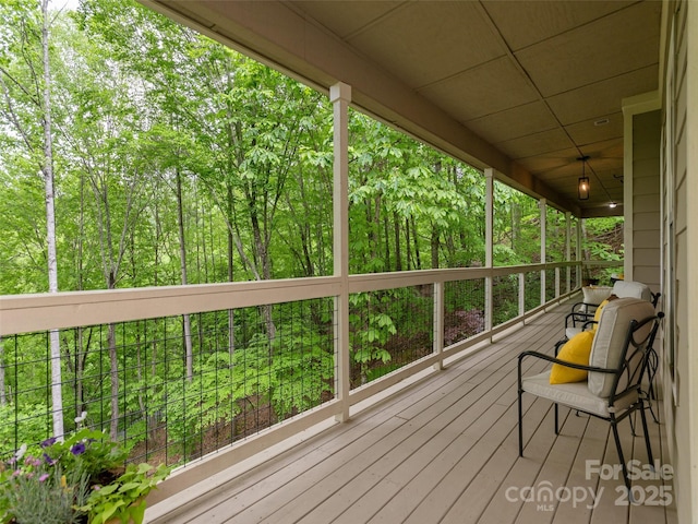 wooden terrace featuring a wooded view