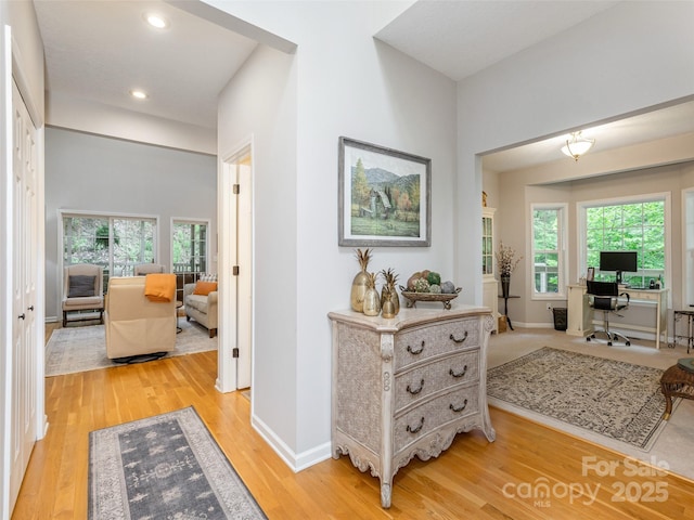 corridor featuring a desk, plenty of natural light, light wood-style floors, and recessed lighting