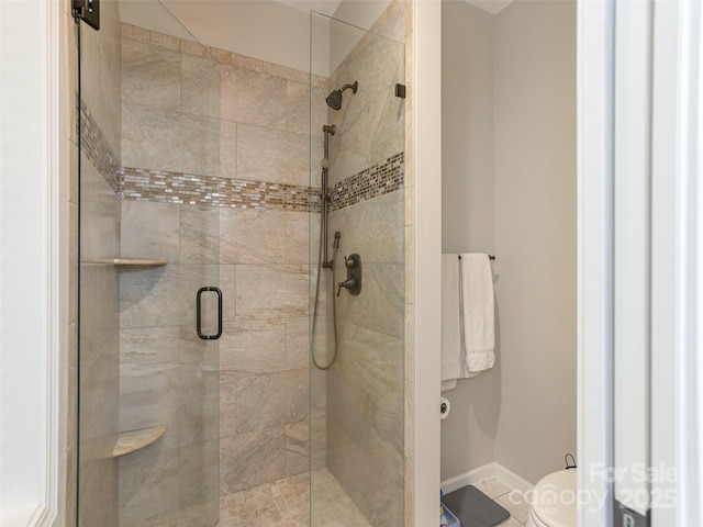bathroom with a shower stall and toilet