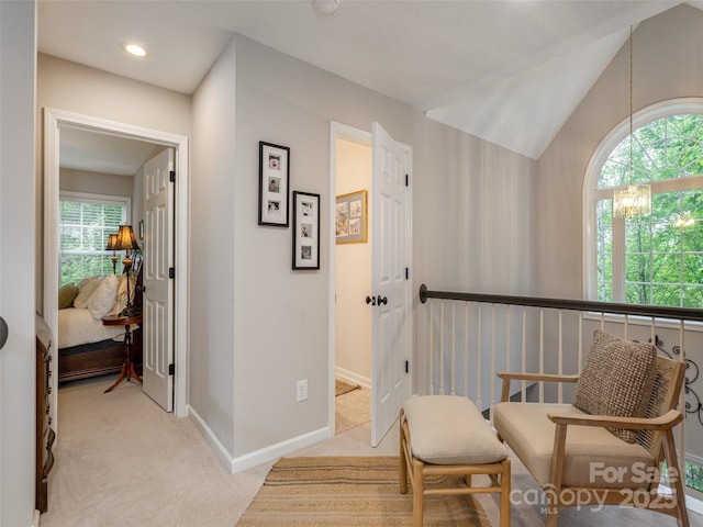 living area with light carpet, a chandelier, baseboards, and vaulted ceiling