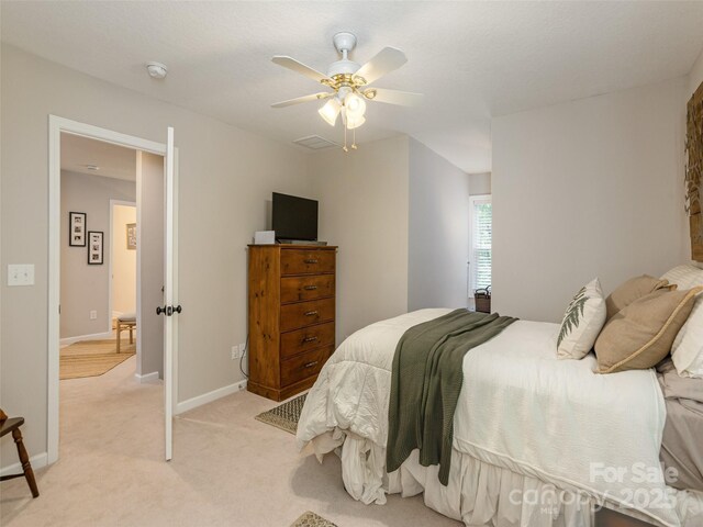 bedroom with light carpet, a ceiling fan, and baseboards