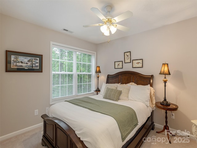 bedroom featuring light colored carpet, baseboards, and a ceiling fan