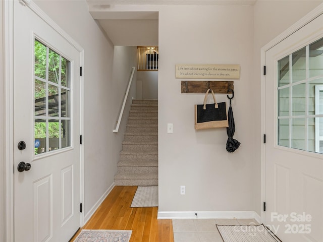 doorway to outside featuring stairs, baseboards, and light wood-type flooring