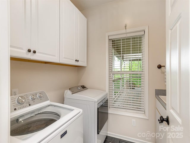 washroom featuring cabinet space, washer and dryer, and baseboards