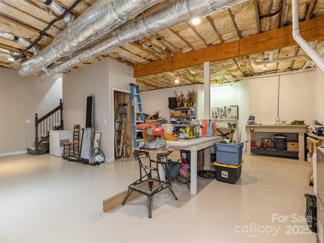 unfinished basement featuring a workshop area and stairs