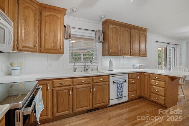 6003 Woodbridge Rd, Charlotte, NC 28227 - kitchen with white appliances, a peninsula, light wood-style floors, plenty of natural light, and crown molding