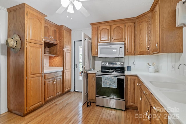 6003 Woodbridge Rd, Charlotte, NC 28227 - kitchen featuring white microwave, stainless steel range with electric cooktop, light wood-style floors, light countertops, and ceiling fan