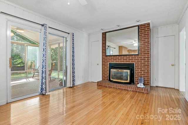 6003 Woodbridge Rd, Charlotte, NC 28227 - unfurnished living room with ceiling fan, wood-type flooring, crown molding, and a brick fireplace