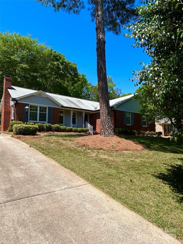 ranch-style house with a front lawn and a chimney