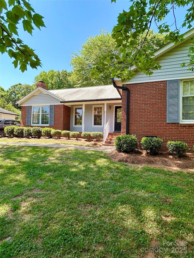 ranch-style house featuring brick siding and a front lawn