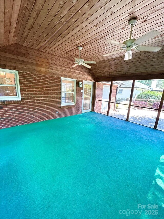 unfurnished sunroom featuring lofted ceiling and plenty of natural light