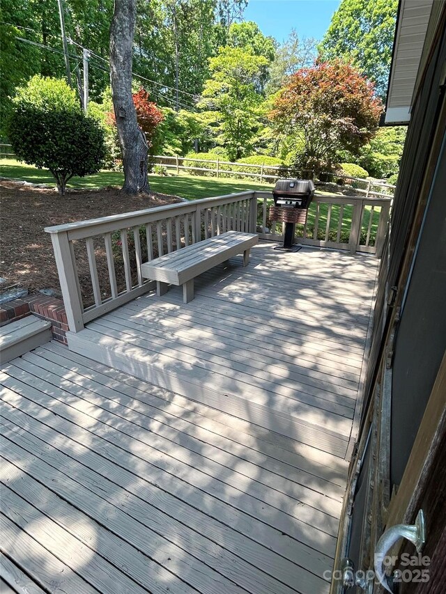 wooden terrace with fence and area for grilling