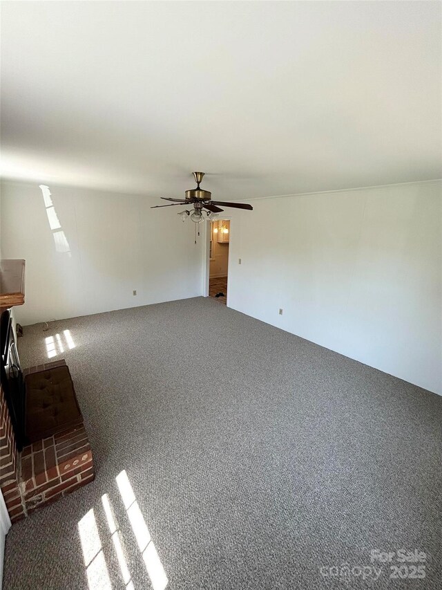 unfurnished living room with ceiling fan and carpet flooring