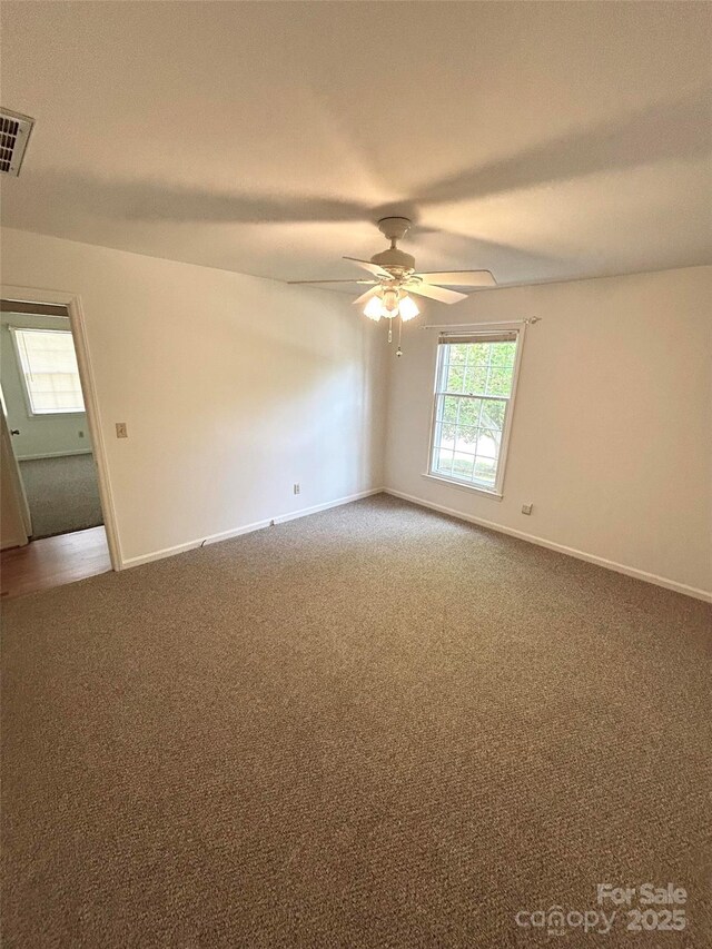 spare room with light colored carpet, a ceiling fan, and baseboards