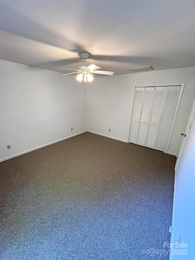 unfurnished bedroom with carpet flooring, baseboards, ceiling fan, and a closet
