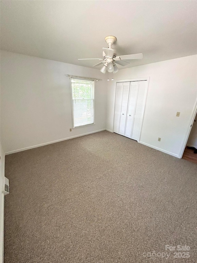 unfurnished bedroom with baseboards, carpet flooring, a closet, and a ceiling fan