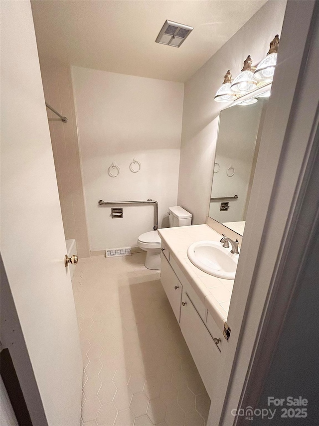 bathroom with toilet, tile patterned flooring, and vanity