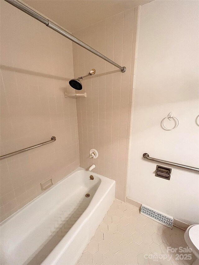 bathroom with tile patterned flooring, shower / washtub combination, and toilet