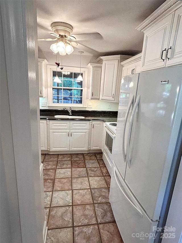 kitchen featuring white appliances, a sink, white cabinetry, dark countertops, and a ceiling fan