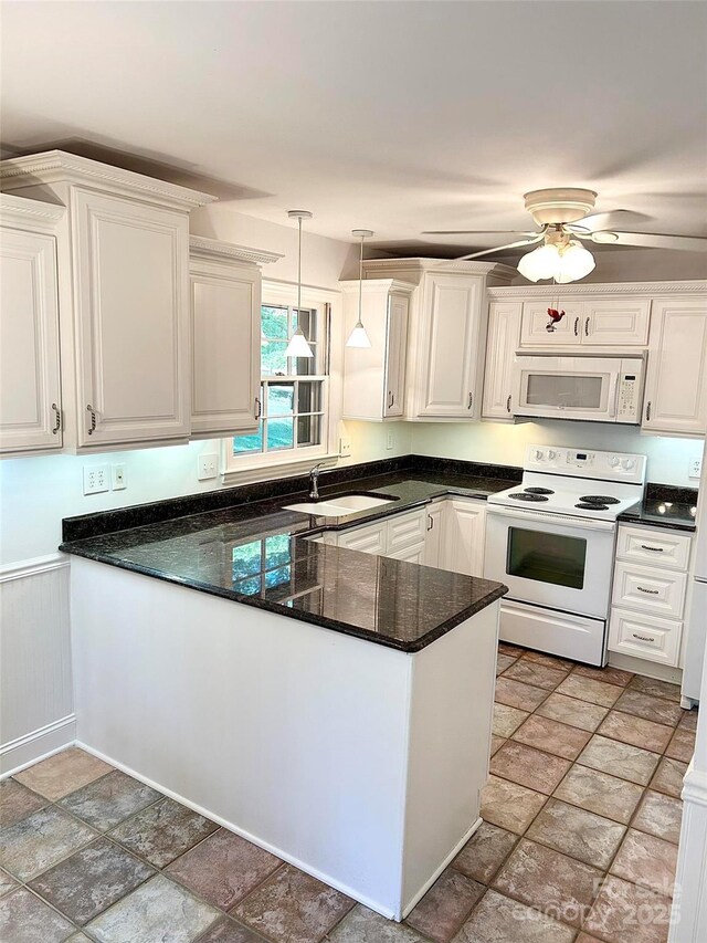 kitchen with white appliances, a sink, light stone finish floors, and white cabinets