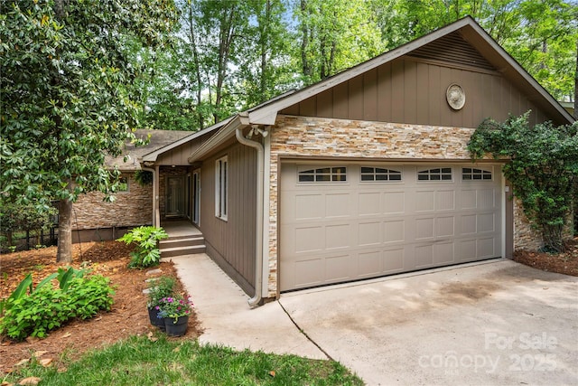 view of property exterior featuring stone siding, a garage, and concrete driveway