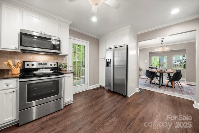 kitchen featuring appliances with stainless steel finishes, dark wood finished floors, white cabinets, decorative backsplash, and ornamental molding