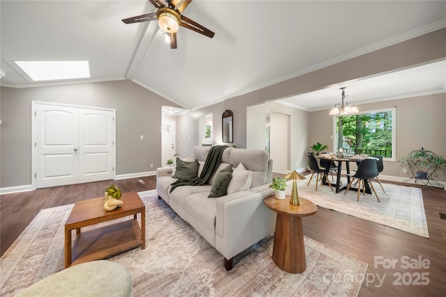 living area with wood finished floors, a ceiling fan, baseboards, lofted ceiling, and ornamental molding
