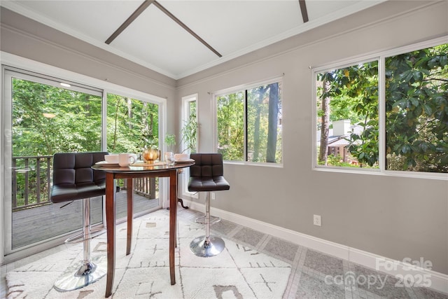 sunroom / solarium with baseboards, ornamental molding, and inlaid floor details