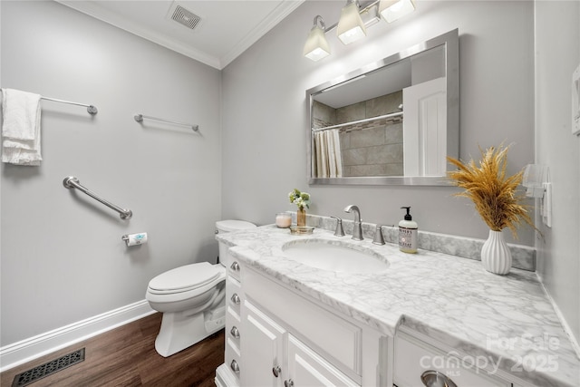 bathroom with ornamental molding, wood finished floors, toilet, baseboards, and vanity