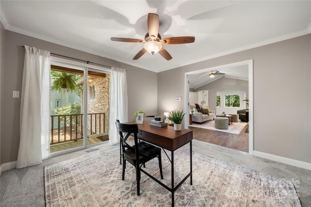 carpeted home office with plenty of natural light, a ceiling fan, baseboards, crown molding, and vaulted ceiling
