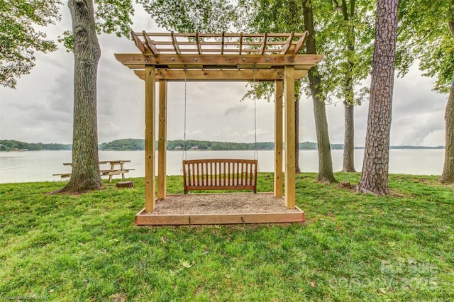 view of green lawn featuring a pergola and a water view