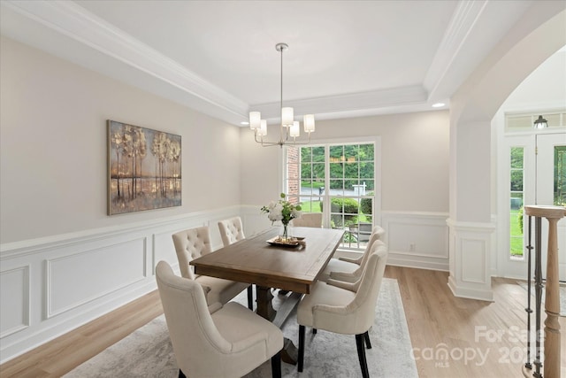601 Carver Pond Ln, Waxhaw, NC 28173 - dining space featuring light wood-style flooring, a chandelier, a decorative wall, a raised ceiling, and a wainscoted wall