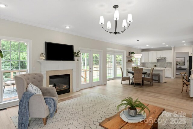 601 Carver Pond Ln, Waxhaw, NC 28173 - living room with crown molding, plenty of natural light, a fireplace with flush hearth, light wood finished floors, and recessed lighting