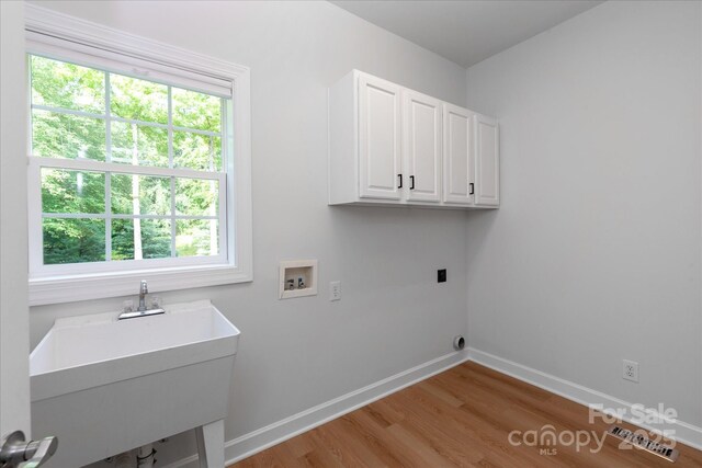 601 Carver Pond Ln, Waxhaw, NC 28173 - washroom featuring hookup for a washing machine, cabinet space, light wood-type flooring, and baseboards