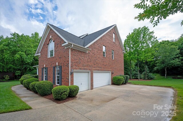601 Carver Pond Ln, Waxhaw, NC 28173 - view of home's exterior featuring brick siding, a garage, driveway, and a lawn