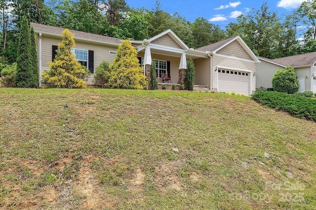view of front of home featuring a porch, an attached garage, and a front yard